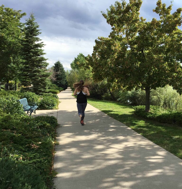 A woman running through a scenic Denver, Colorado landscape.