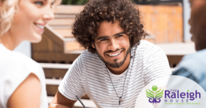 A young man chats happily with two friends. 