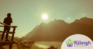  The silhouette of a man as he watches the sun set behind a mountain. 