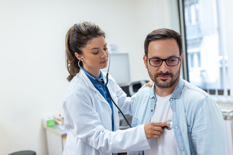A doctor checks the heart rate of her patient.