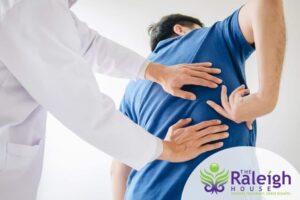 A doctor examines the source of a patient’s lower back pain.
