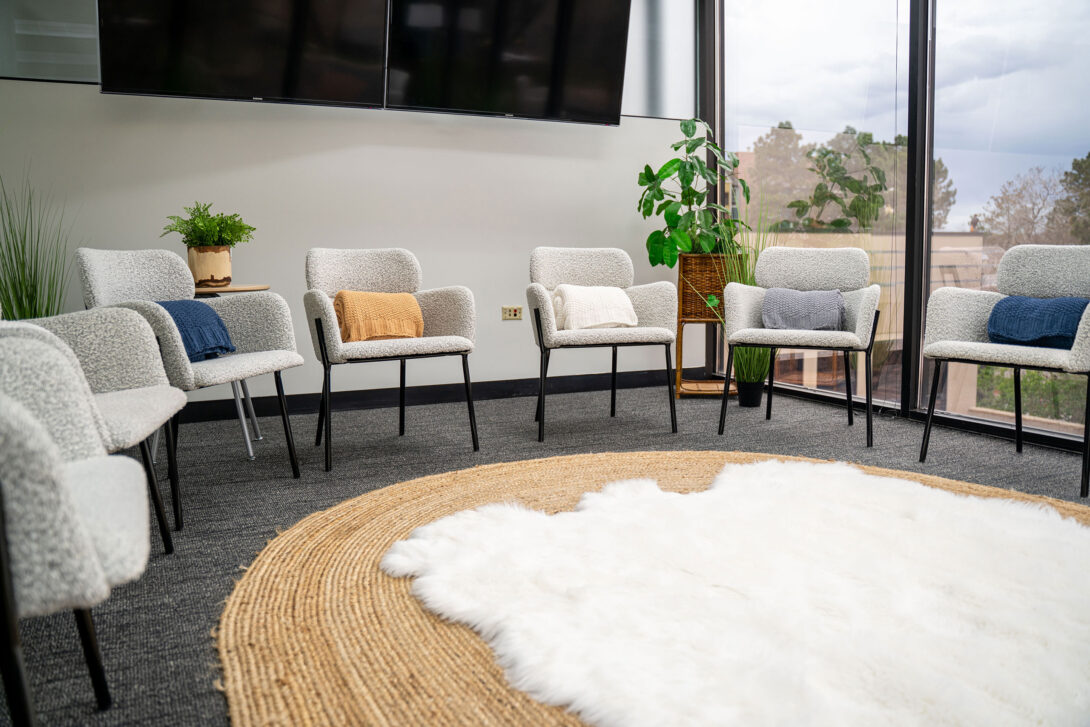 Group meeting area with white chairs and large TV screens