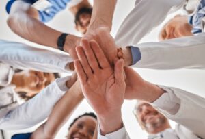 Medical, team and hand together in collaboration at clinic