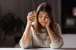 sad woman with glass of alcohol