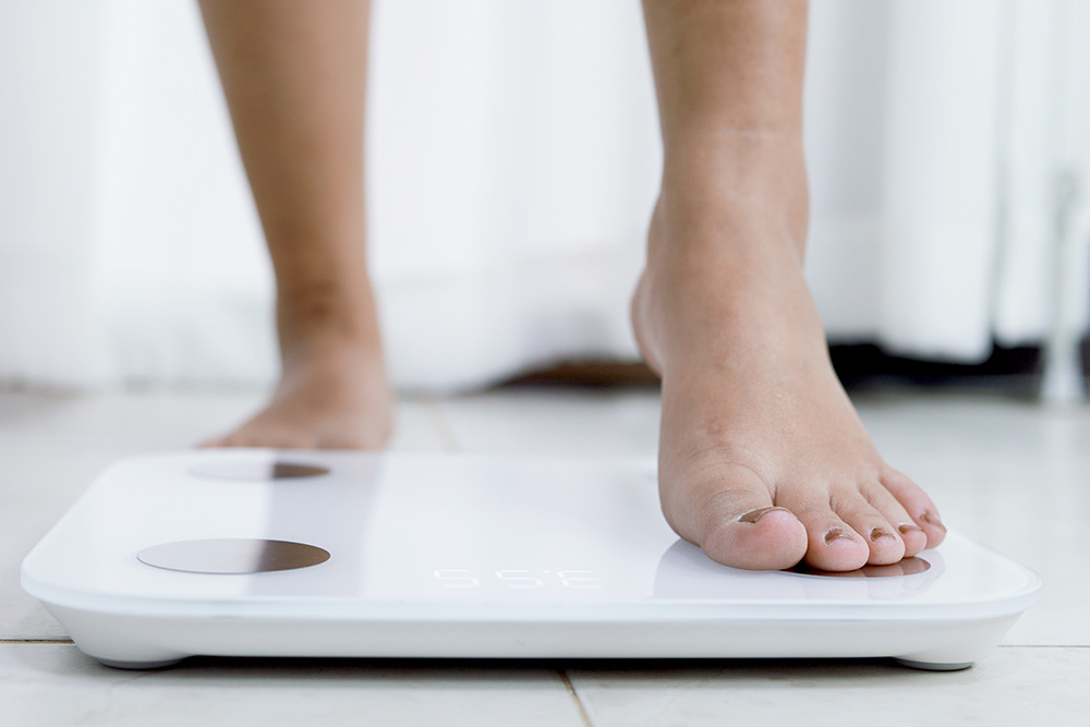 woman stepping on scale