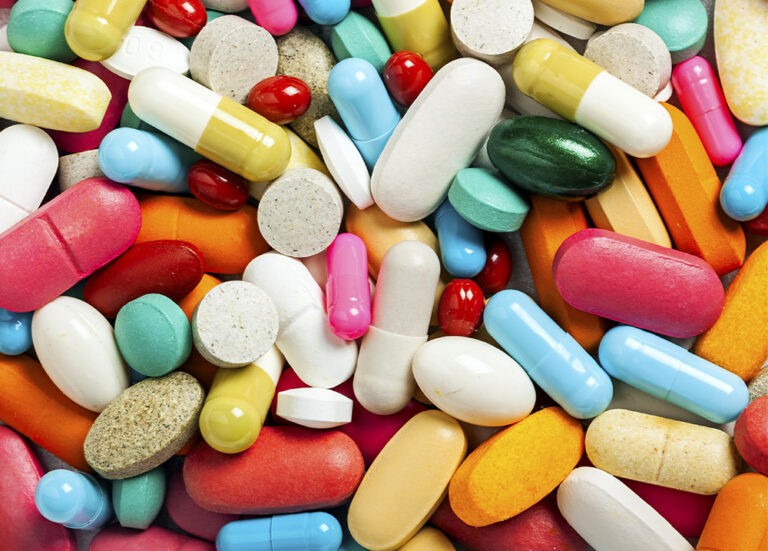 An assortment of brightly colored pills on a table.