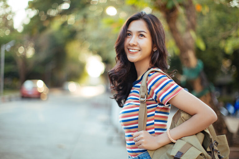 Young woman standing on the street with a backpack
