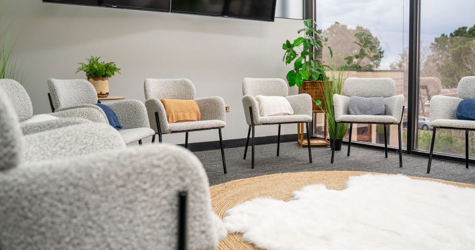 Group meeting area with white chairs and large TV screens